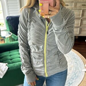 Gray zip up athletic jacket with yellow zipper and thumb holes